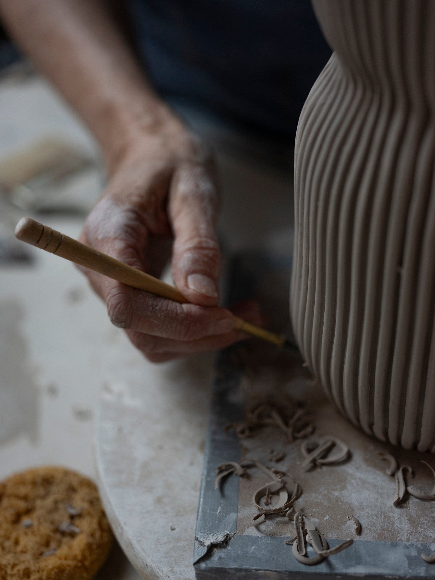 Potter carving details on a clay vase, DSF3393