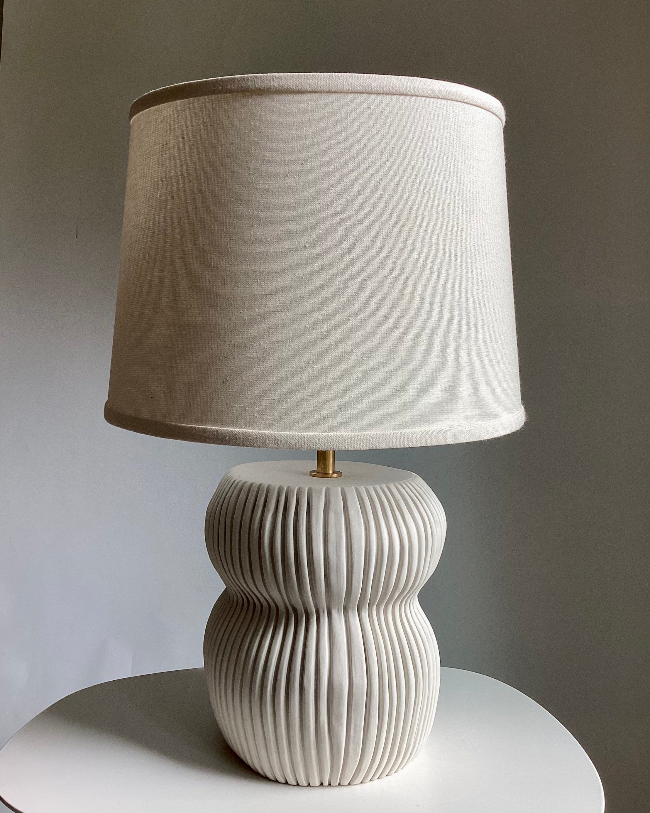 Table lamp with a beige lampshade.