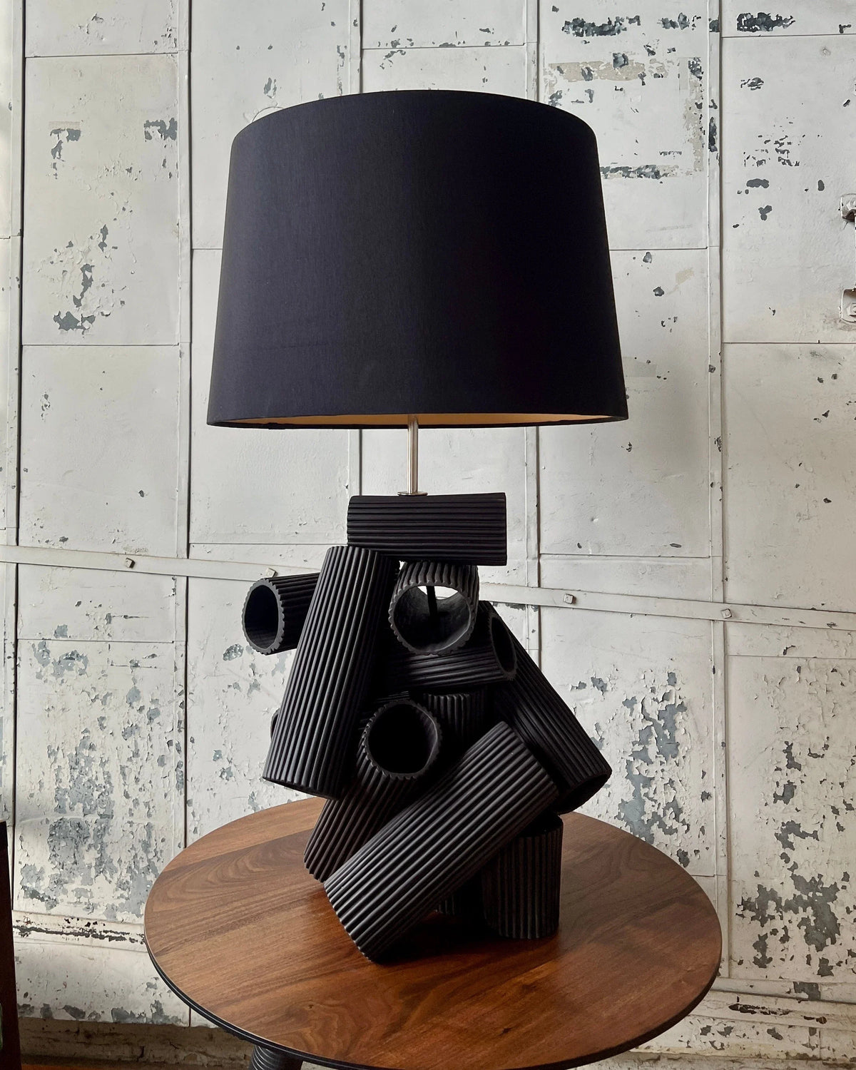 Black lamp with a unique, geometric base on a wooden table