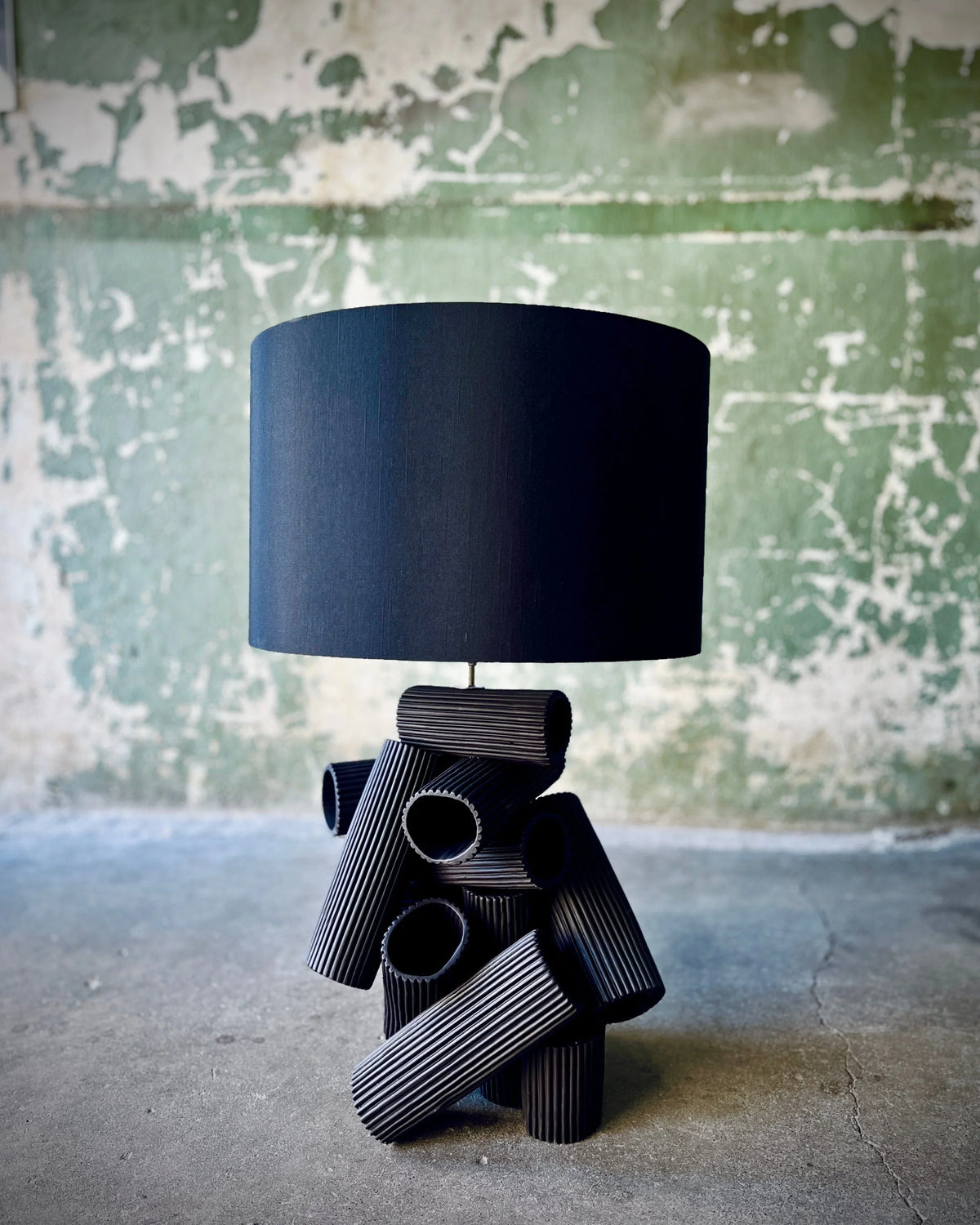 Black table lamp with cylindrical base and shade