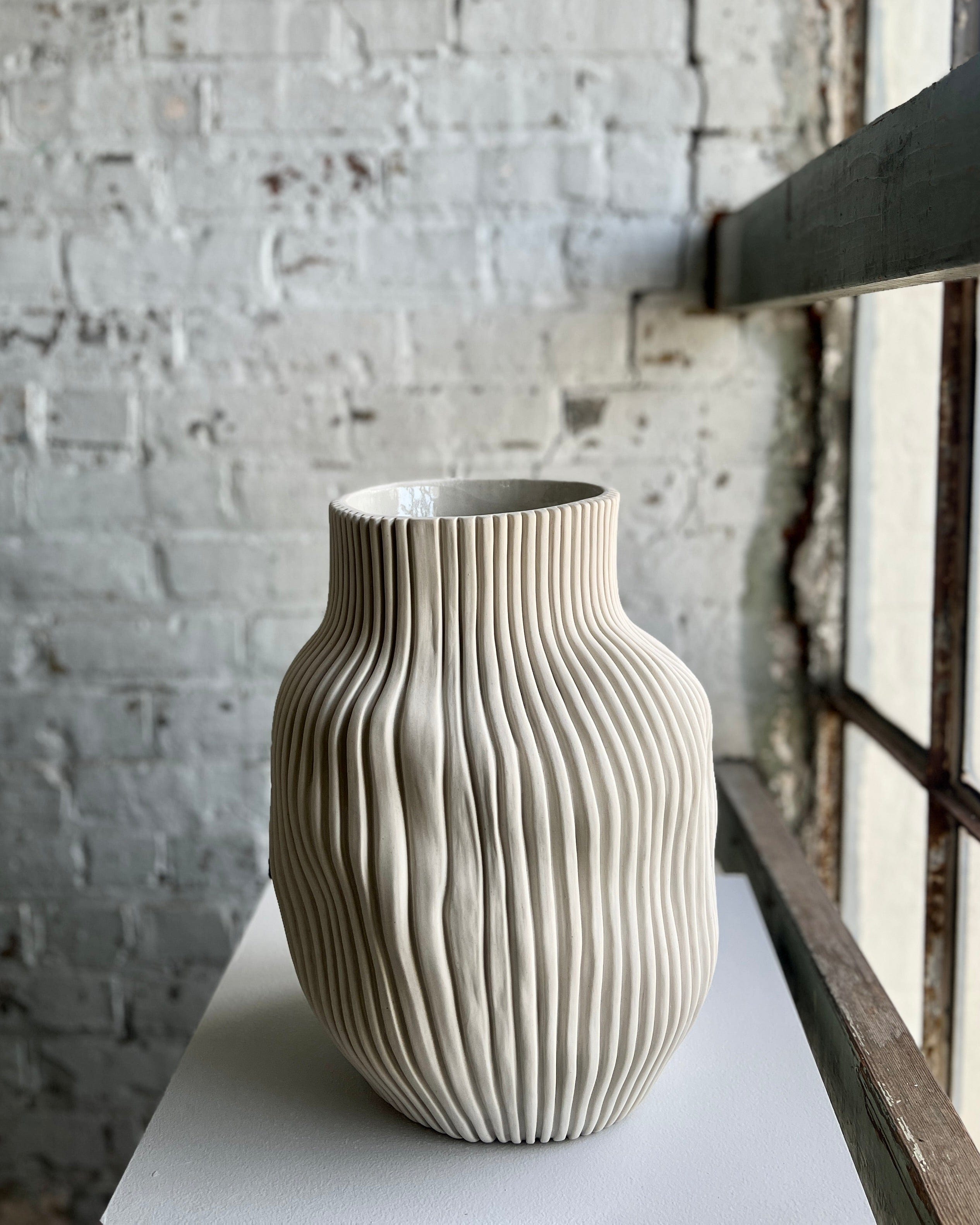 Textured ceramic vase on white surface