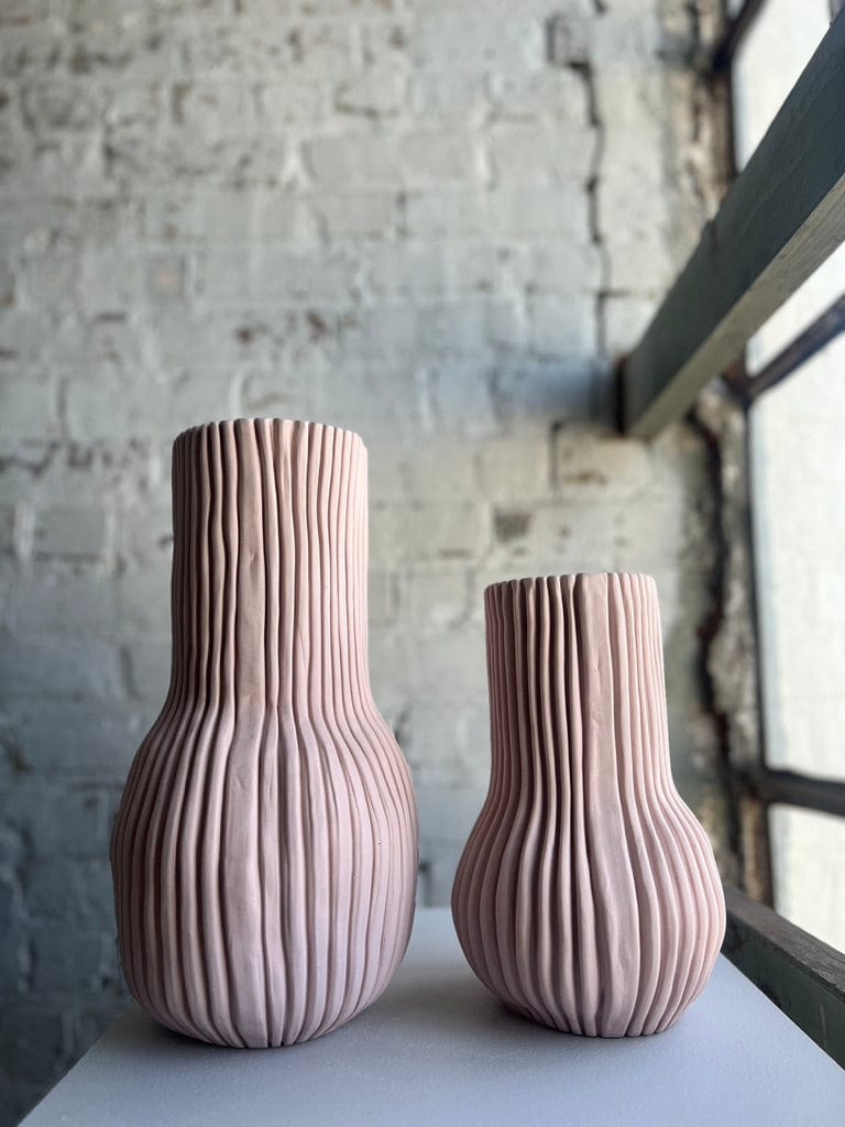 Two pink ribbed ceramic vases