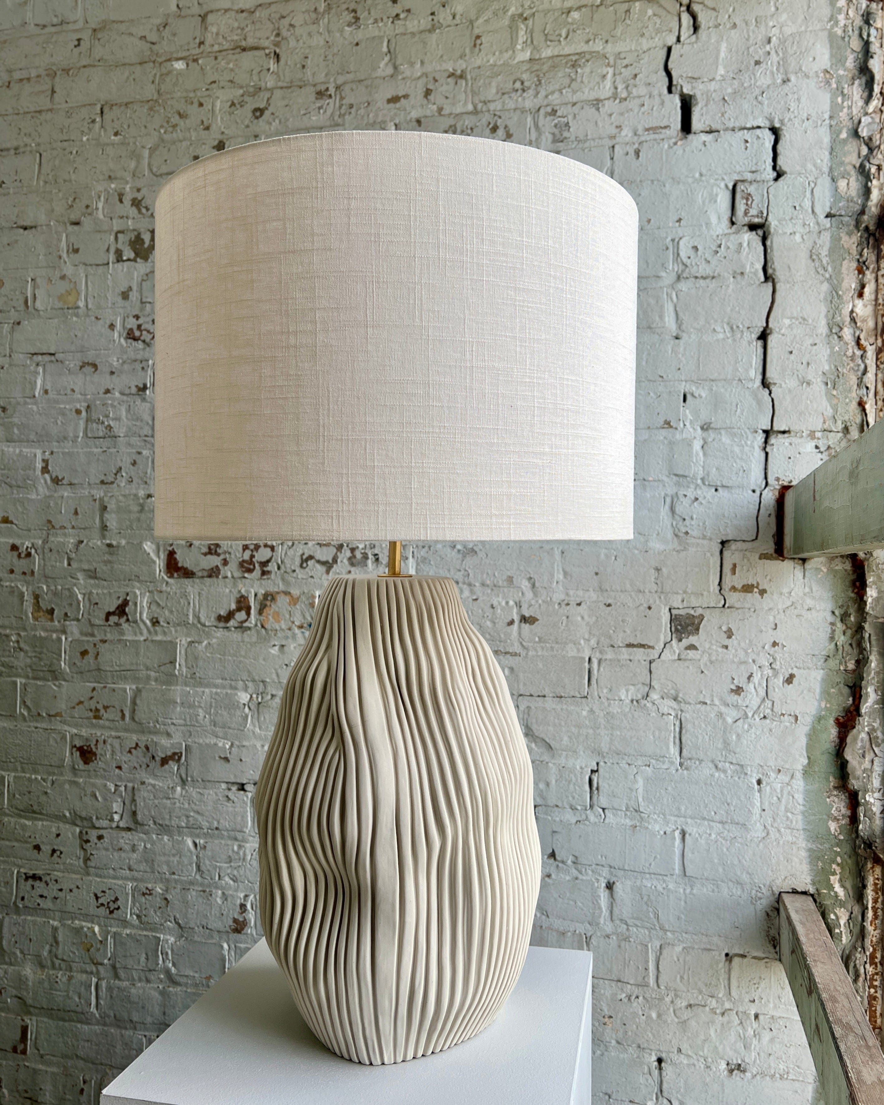 Beige lamp with textured base and lampshade.
