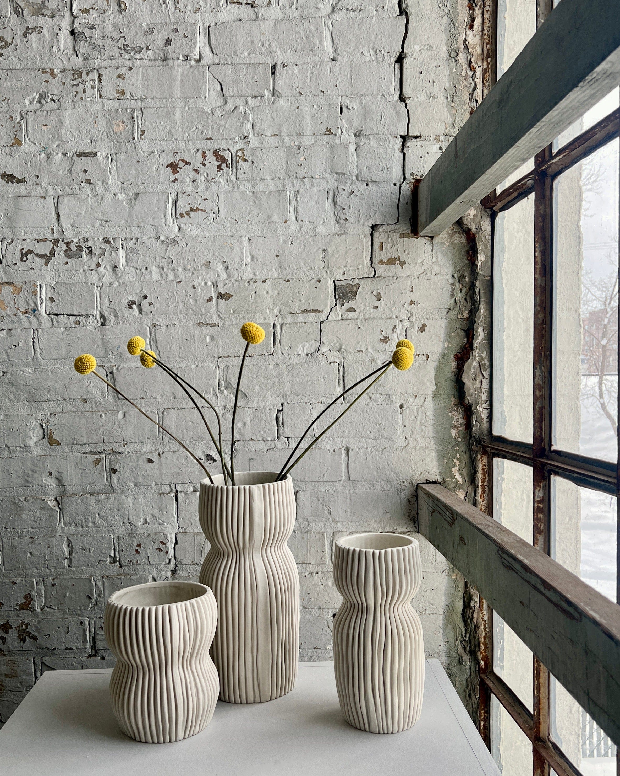 Three vases with yellow flowers.
