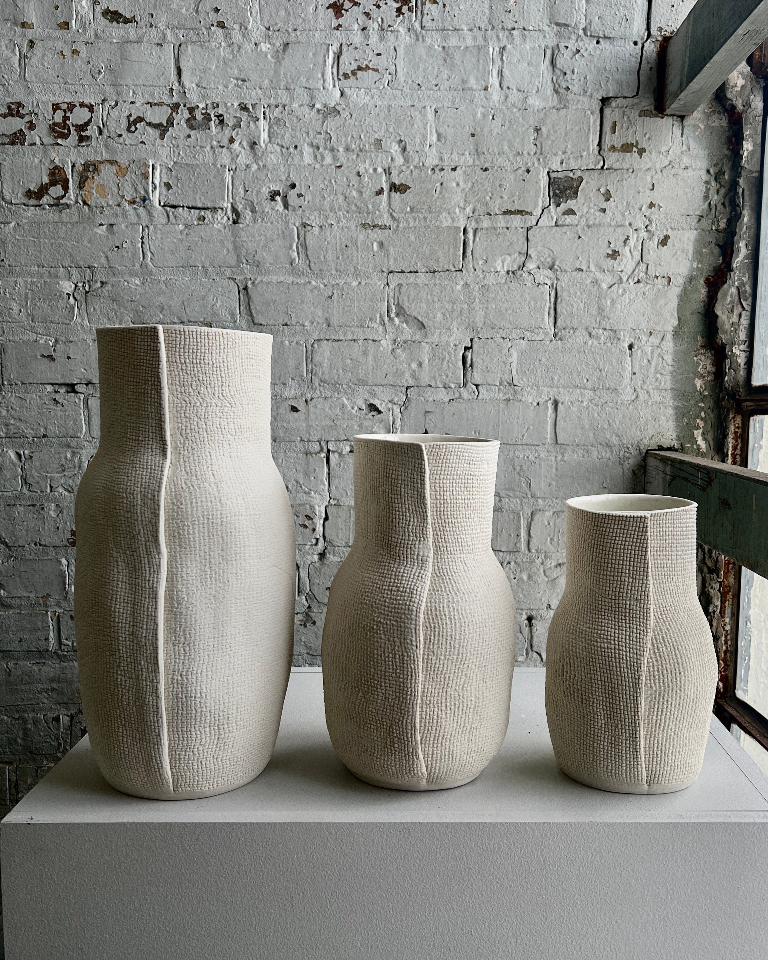 Three textured white vases.
