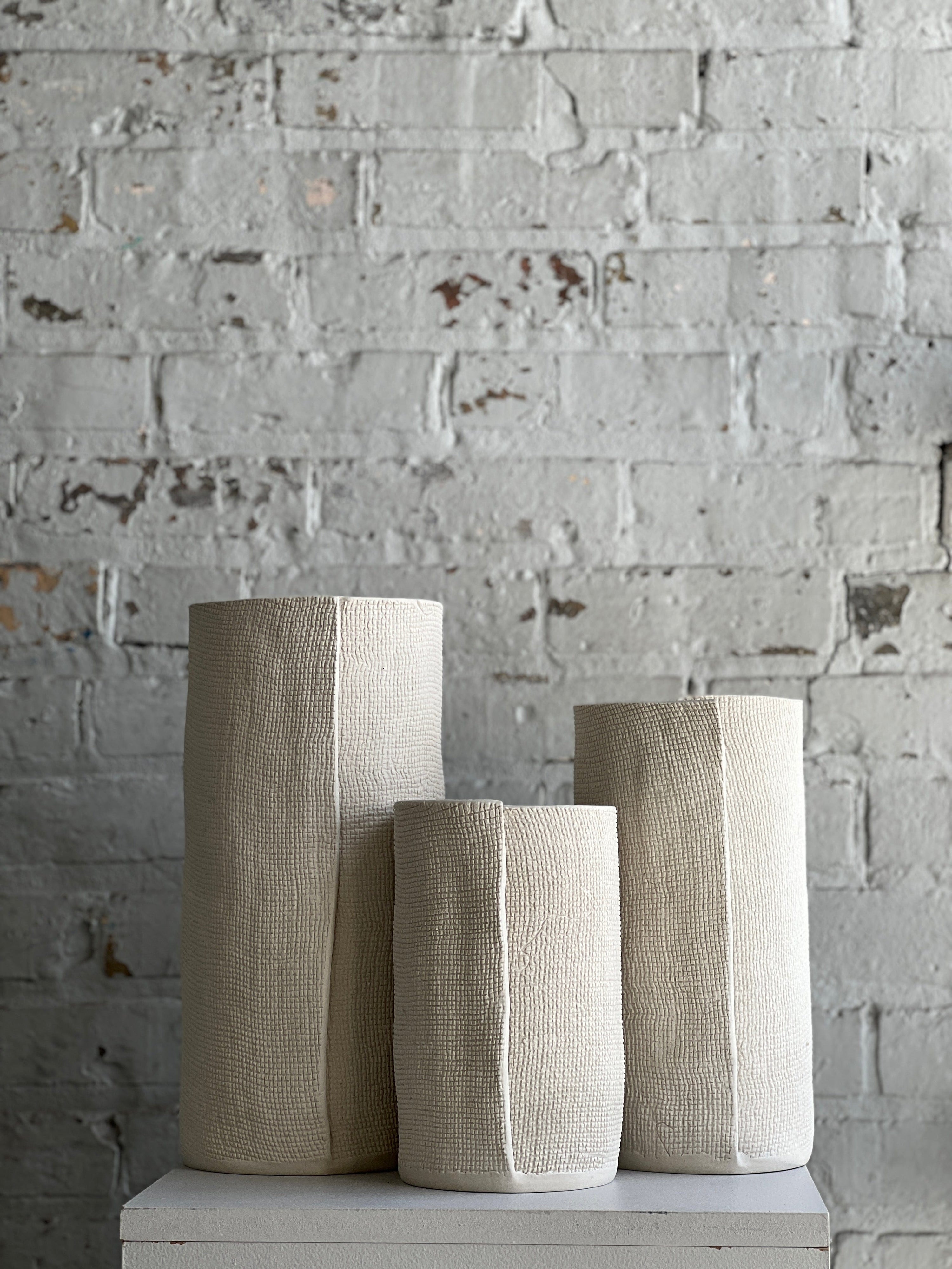 Three textured beige vases.