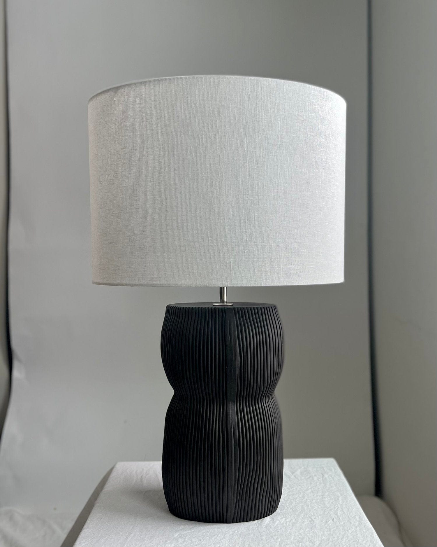 Black lamp with white lampshade.