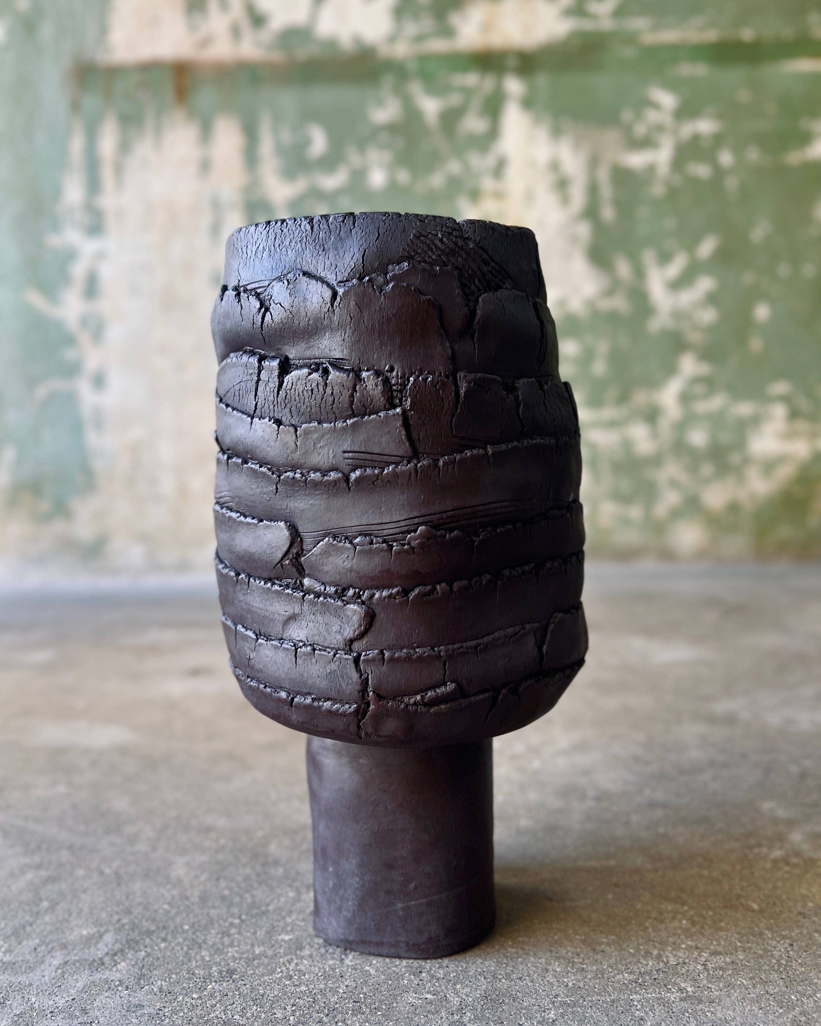 Black, textured ceramic vase.