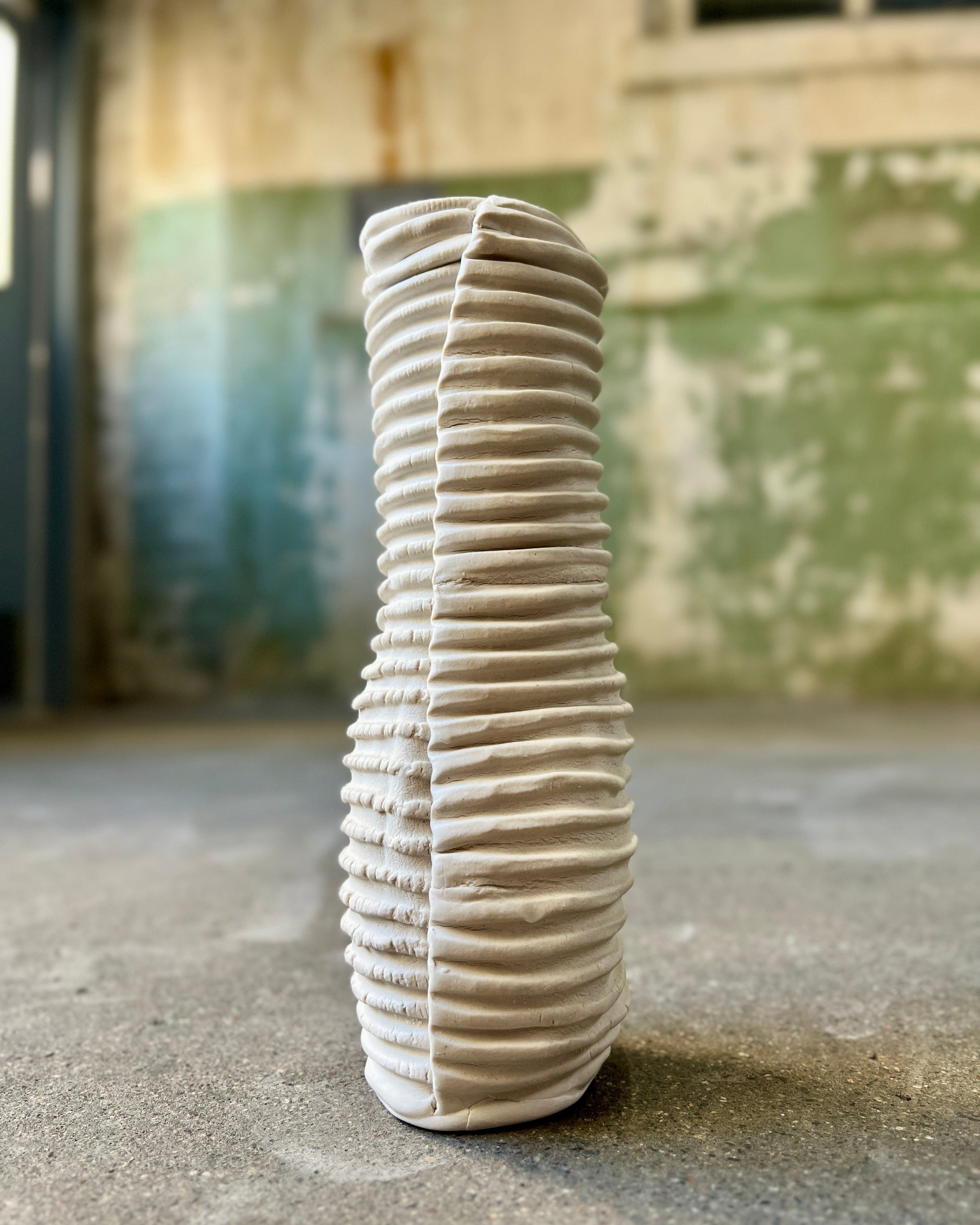 White ceramic vase with textured ridges.