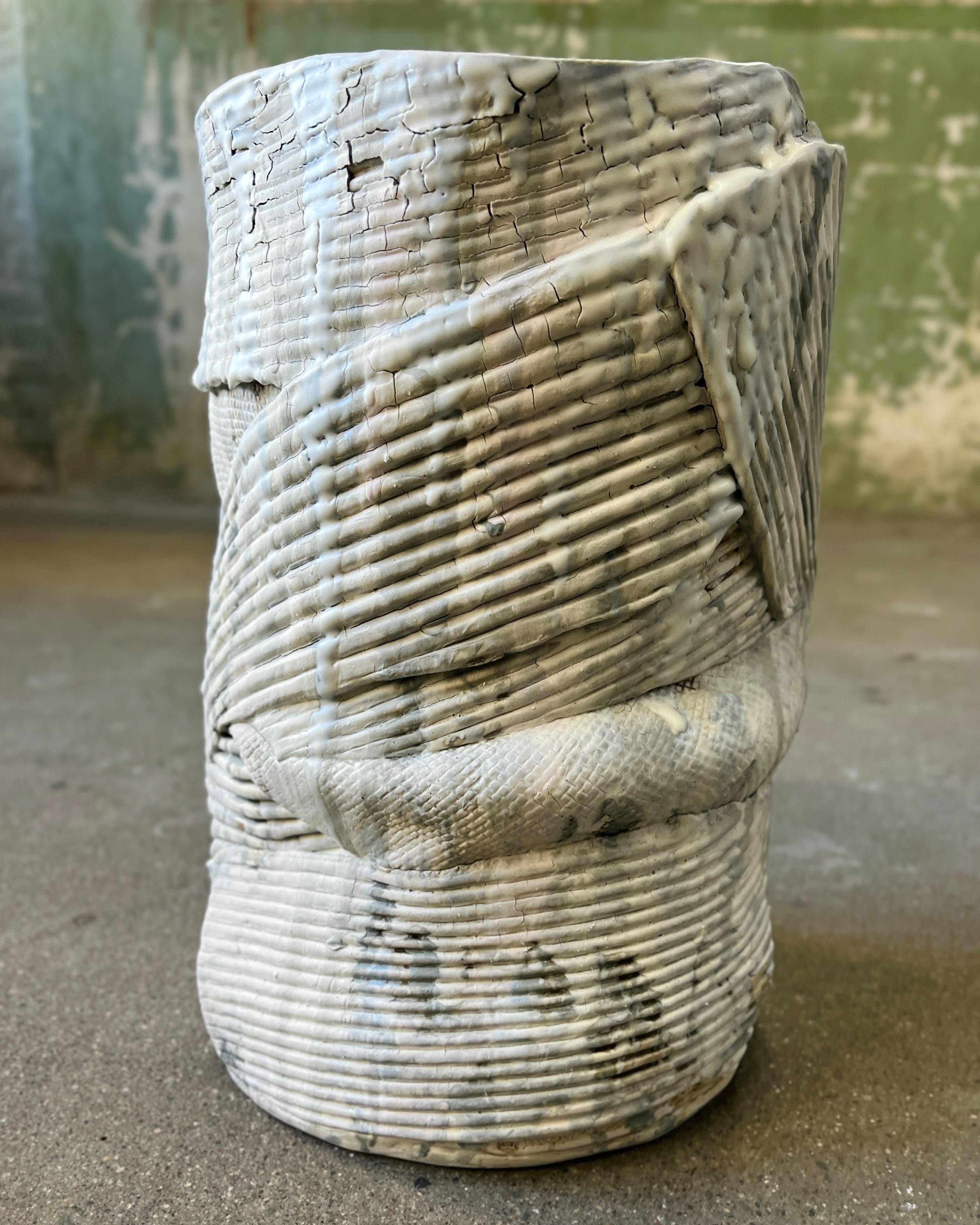 White ceramic vase with textured, layered design.