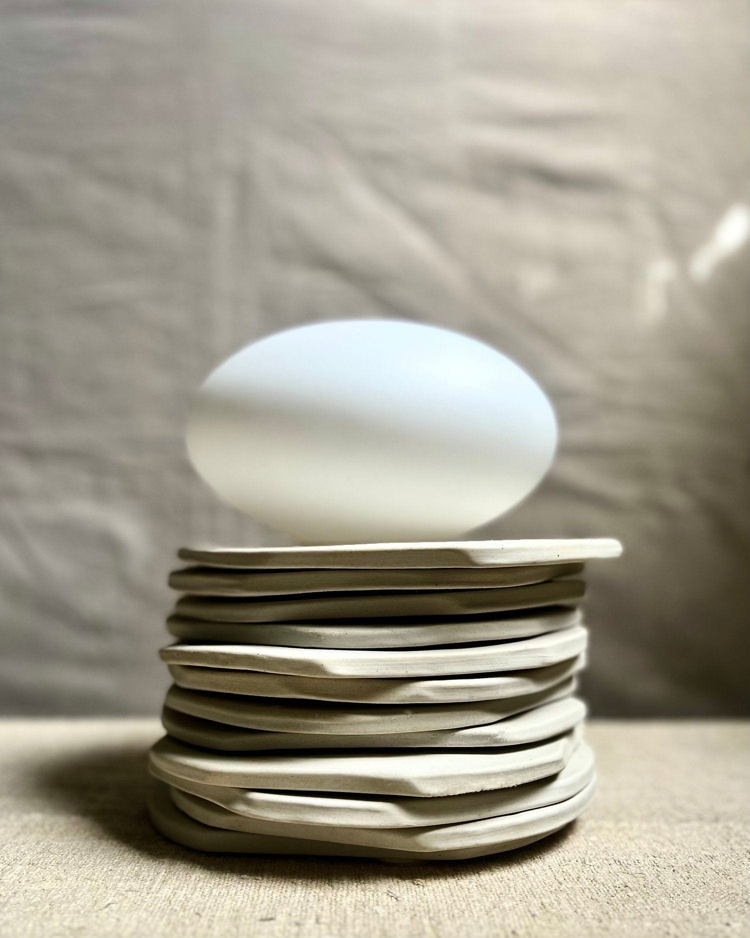 Stack of plates with a white oval object on top.