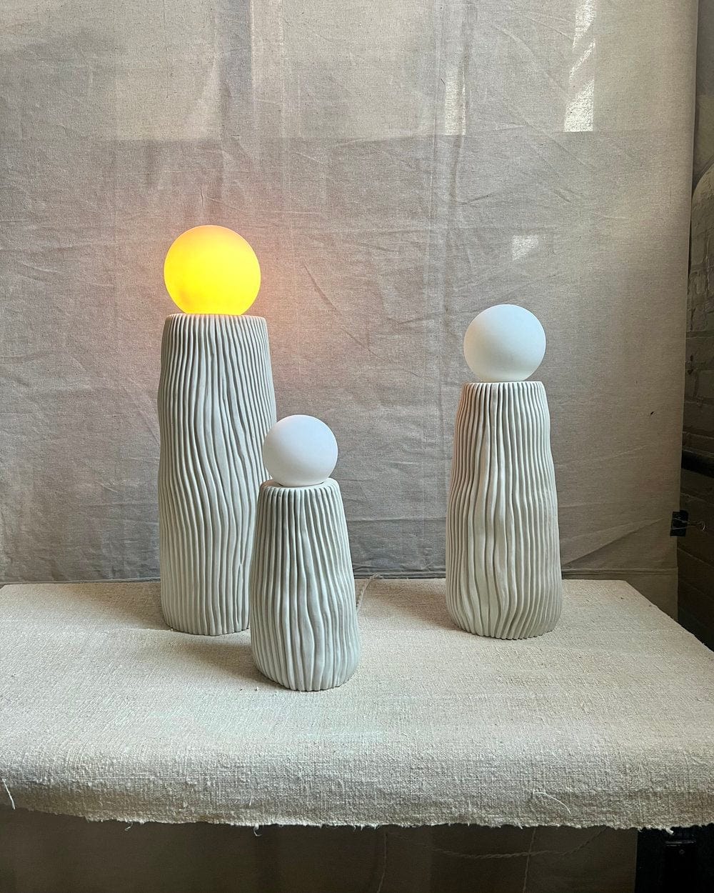 Three textured lamps with glowing orbs.